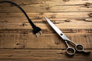 an electric cord and a pair of scissors on a wooden table